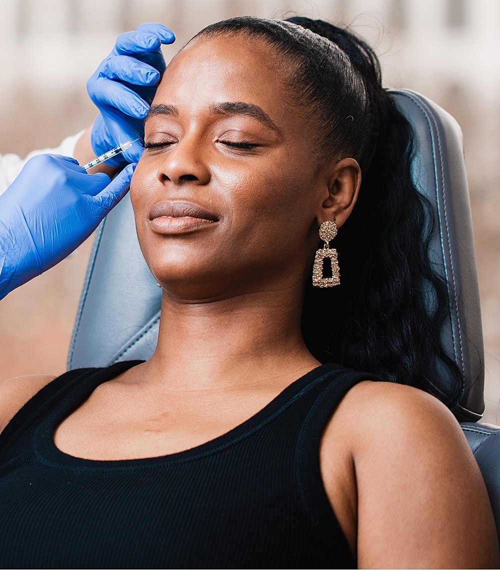 Woman receiving cosmetic treatment in medical setting.