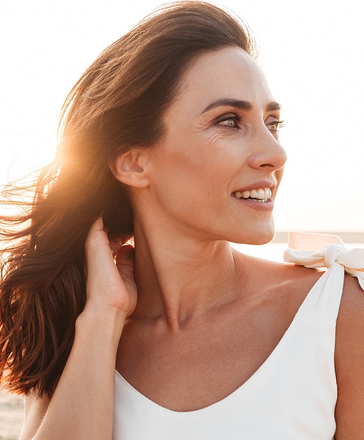 Smiling woman enjoying a sunny day outdoors.