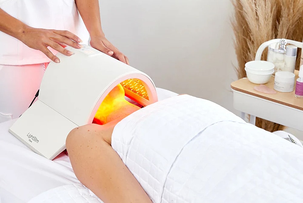 Person receiving light therapy treatment in spa.