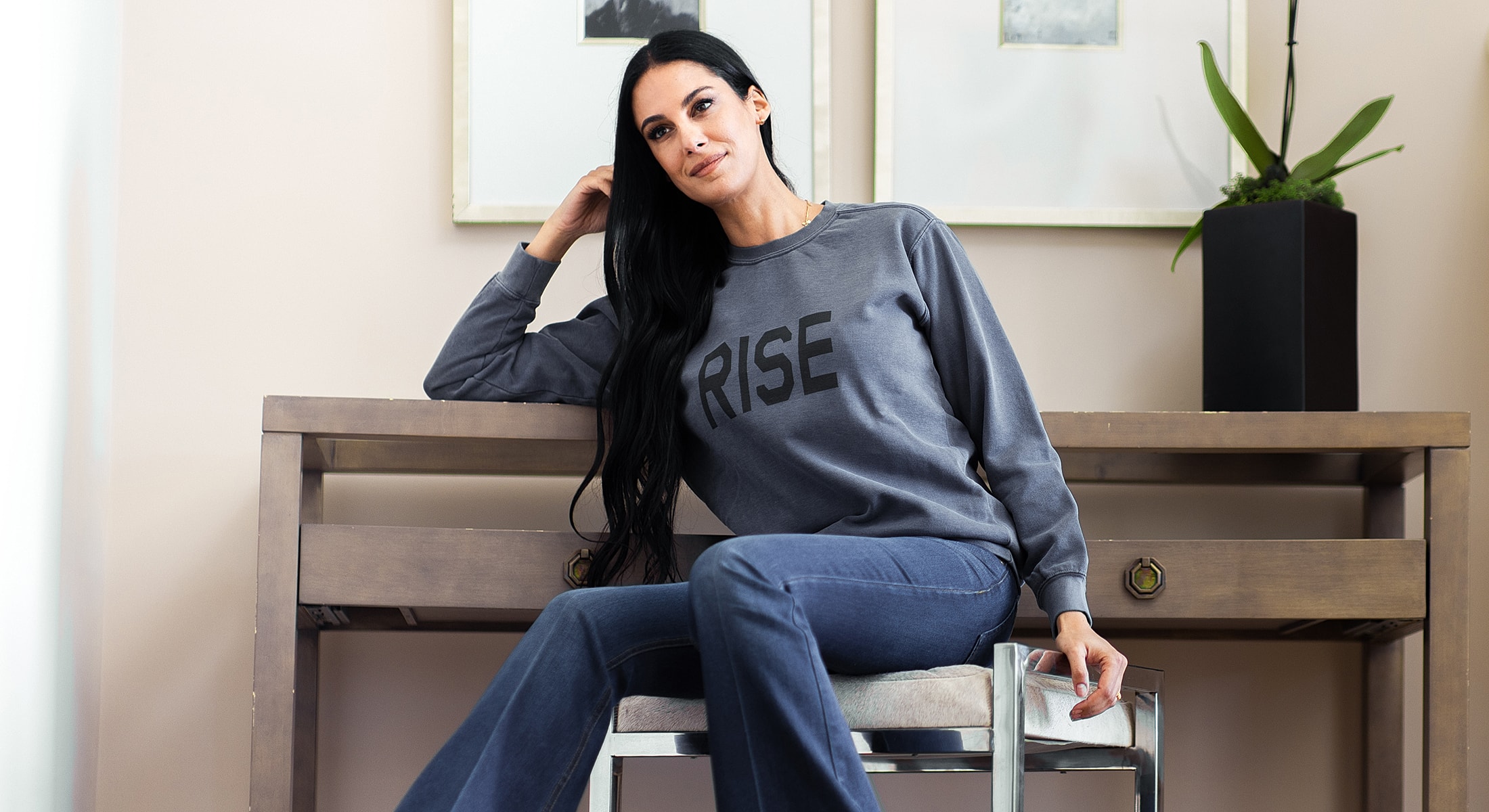 Sr. Sheila Nazarian in casual outfit sitting by a table.