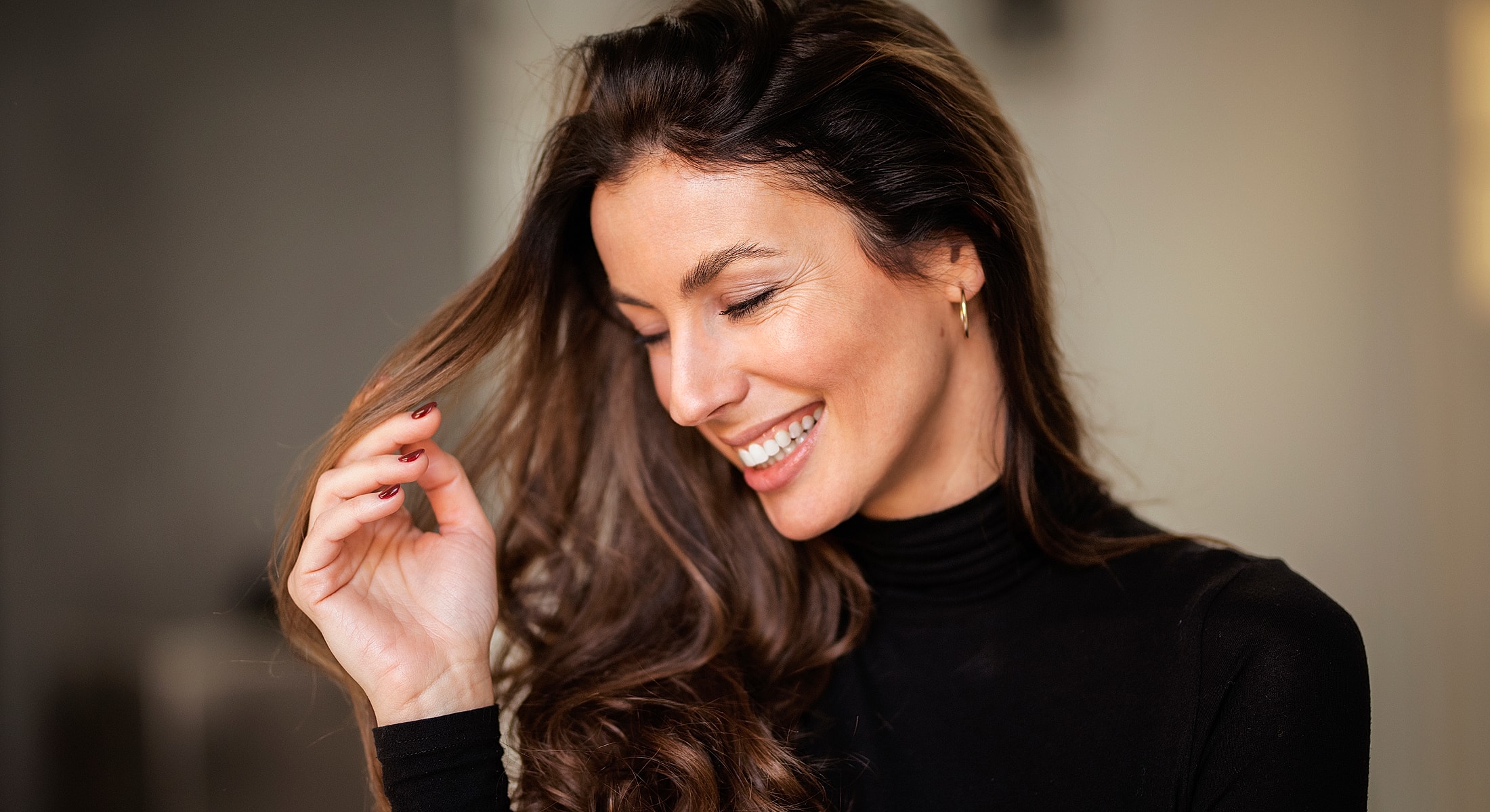 Smiling woman with long, wavy hair.