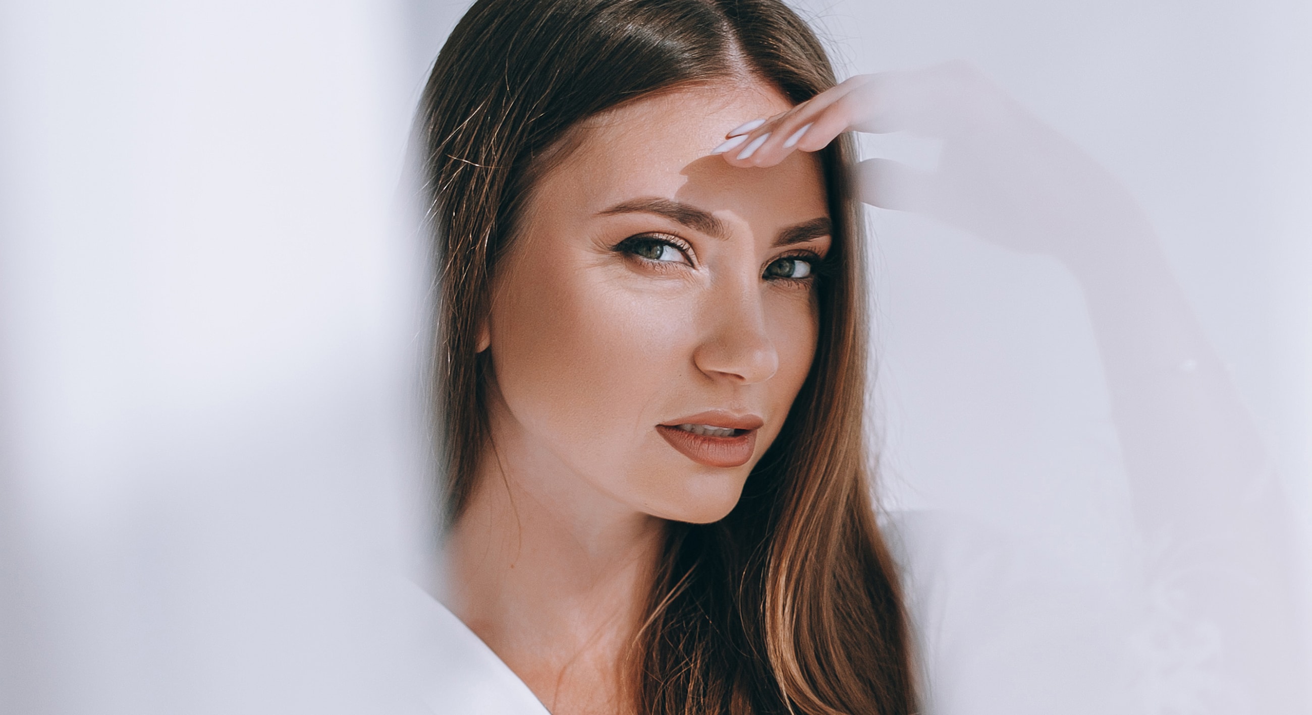 Woman with long hair, posing thoughtfully.